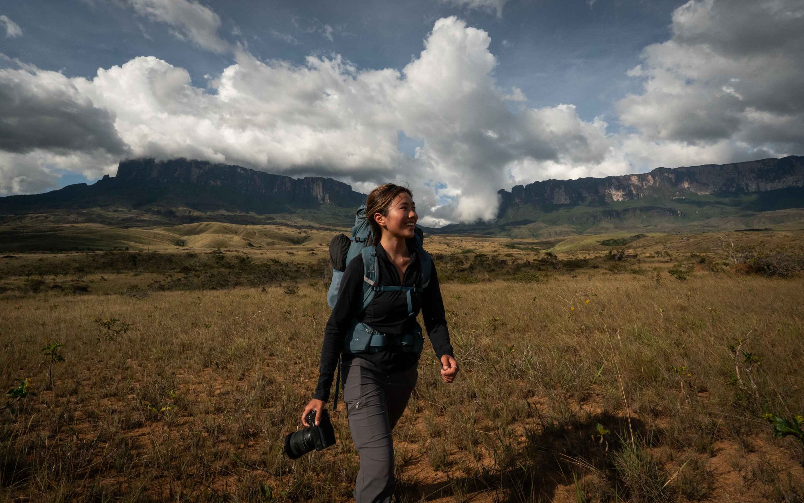 Woman hiking in the Gran Sabana in Venezuela with Mount Roraima Tepui in the distance